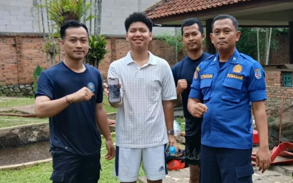 Petugas Damkar Depok berpose bersama mahasiswa pemilik iPhone 15 Pro Max yang berhasil dievakuasi dari dasar kolam di Villa Graha Madani, Sawangan, Depok. (Foto: Dok. Damkar Kota Depok)