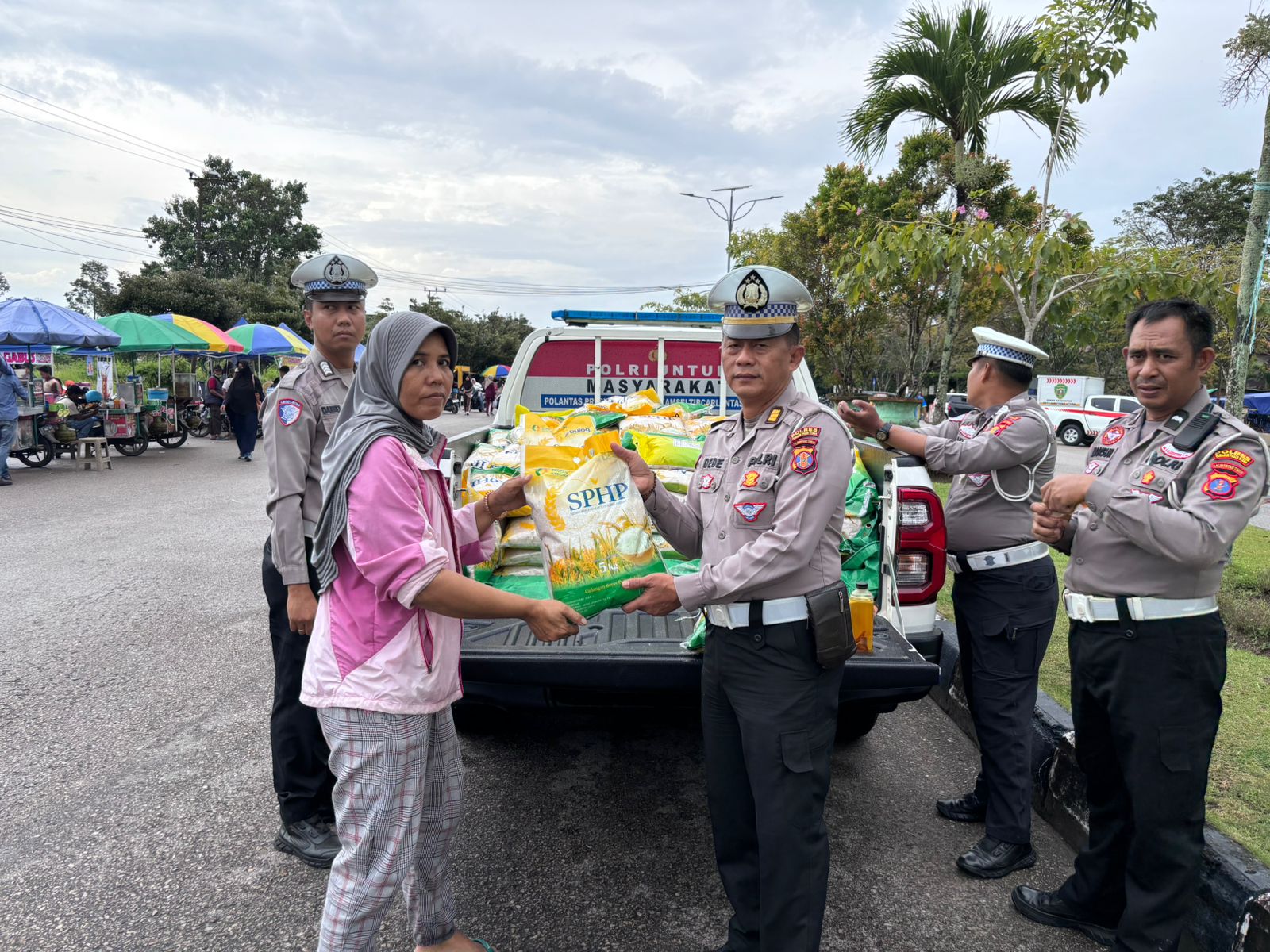 MURAH: Kanit Regident Satlantas Polres PPU AKP Dede Setiawan menyerahkan beras yang dibeli warga pada kegiatan GPM Polres-Bulog. (IST)