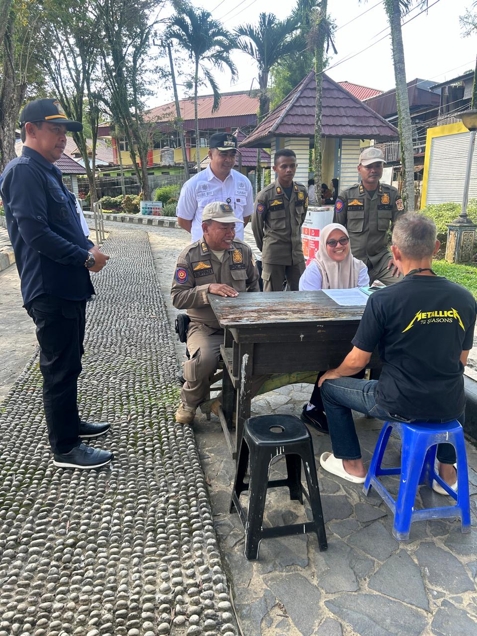 Lurah Karang Rejo Budi (kiri) mendampingi Camat Balikpapan Tengah Agung Budi Wibowo (kemeja putih) menyaksikan pemeriksaan warga yang kedapatan membuang sampah di luas batas waktu.