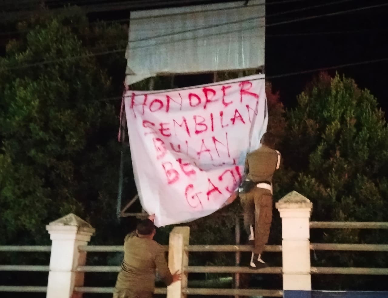 Satpol PP saat melepaskan spanduk yang berisi coretan yang dipasang di sejumlah sekolah di Kubar.