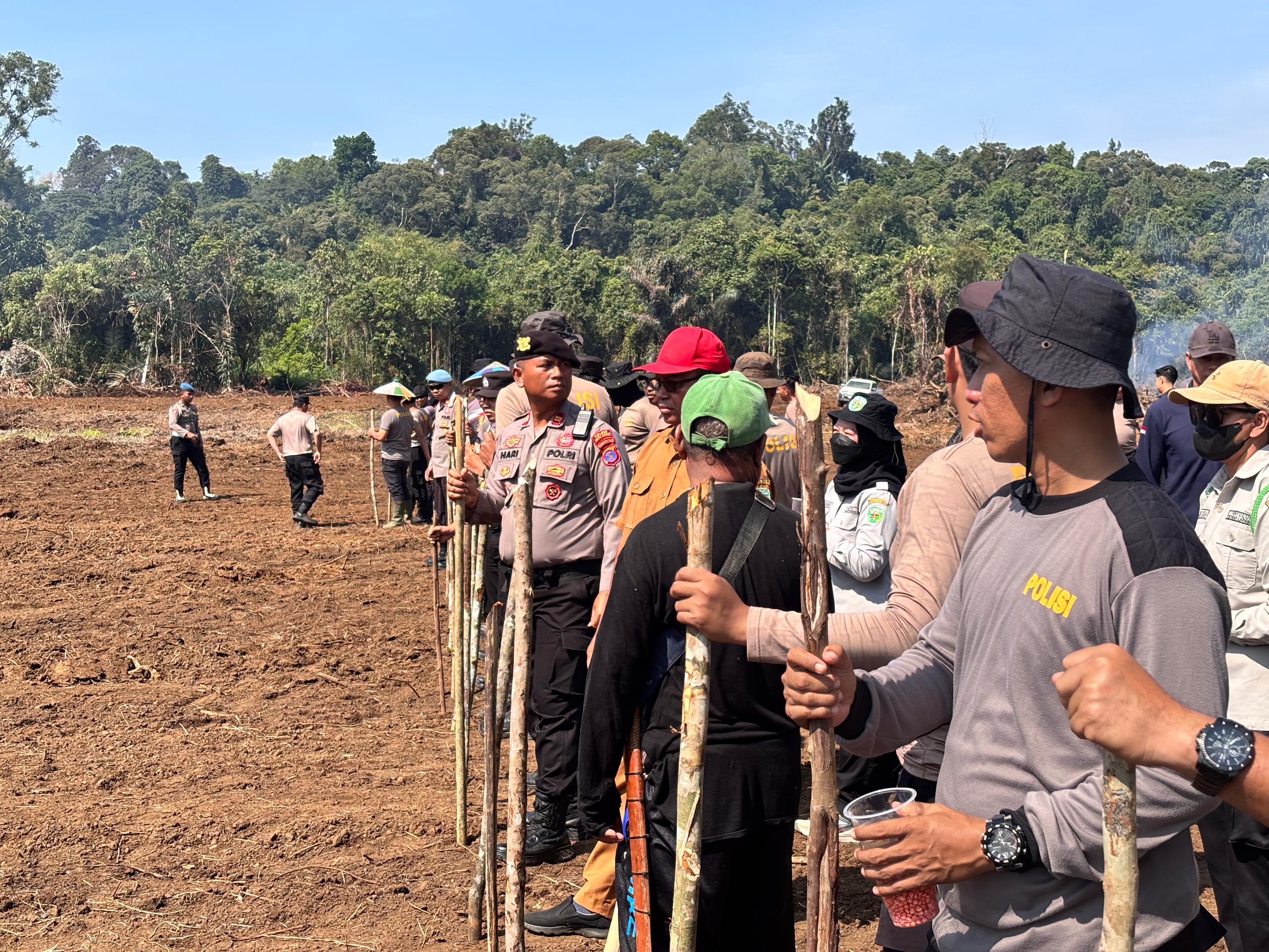 TANAM JAGUNG: Polisi dan Distan Kubar bersama menanam jagung di lahan eks tambang, milik PT Harindo Wahana.
