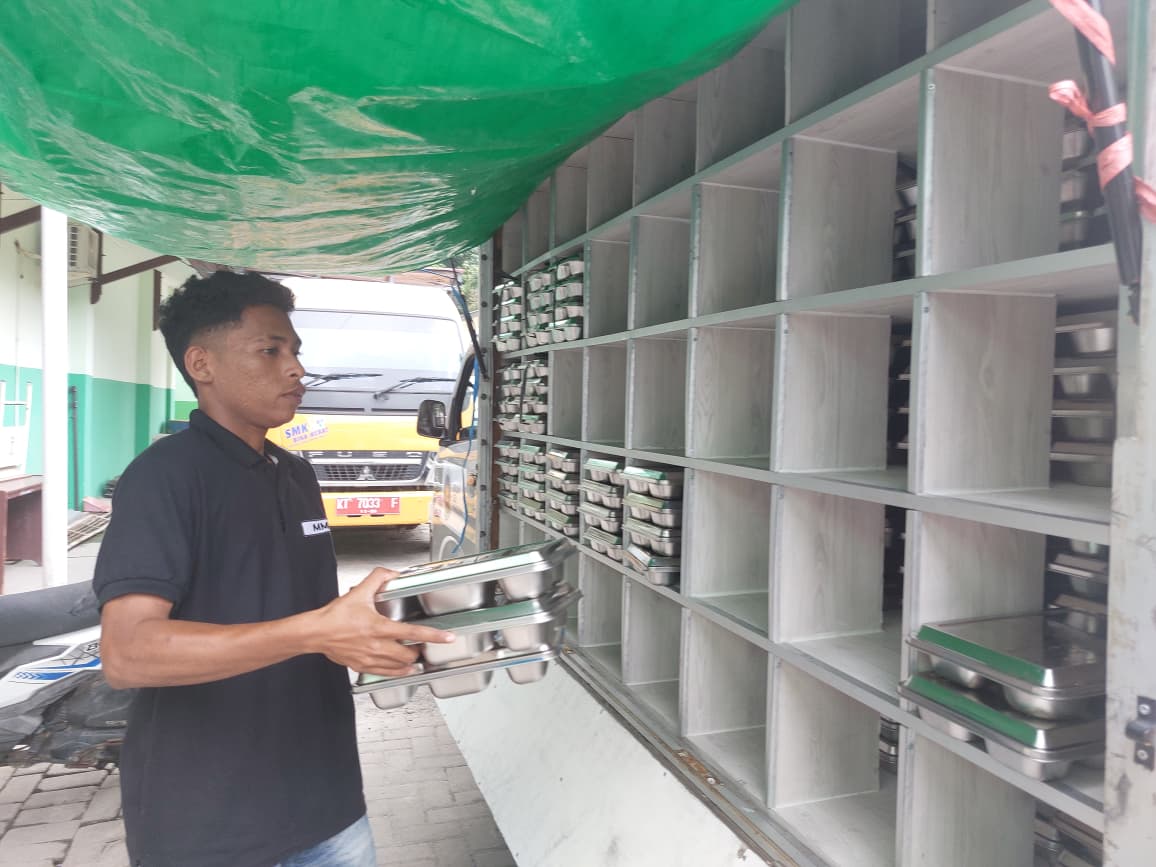 Petugas Satuan Pelayanan Pemenuhan Gizi (SPPG) saat mengambil ompreng MBG yang habis disantap siswa SMK 3 Balikpapan, Jumat (26/9).