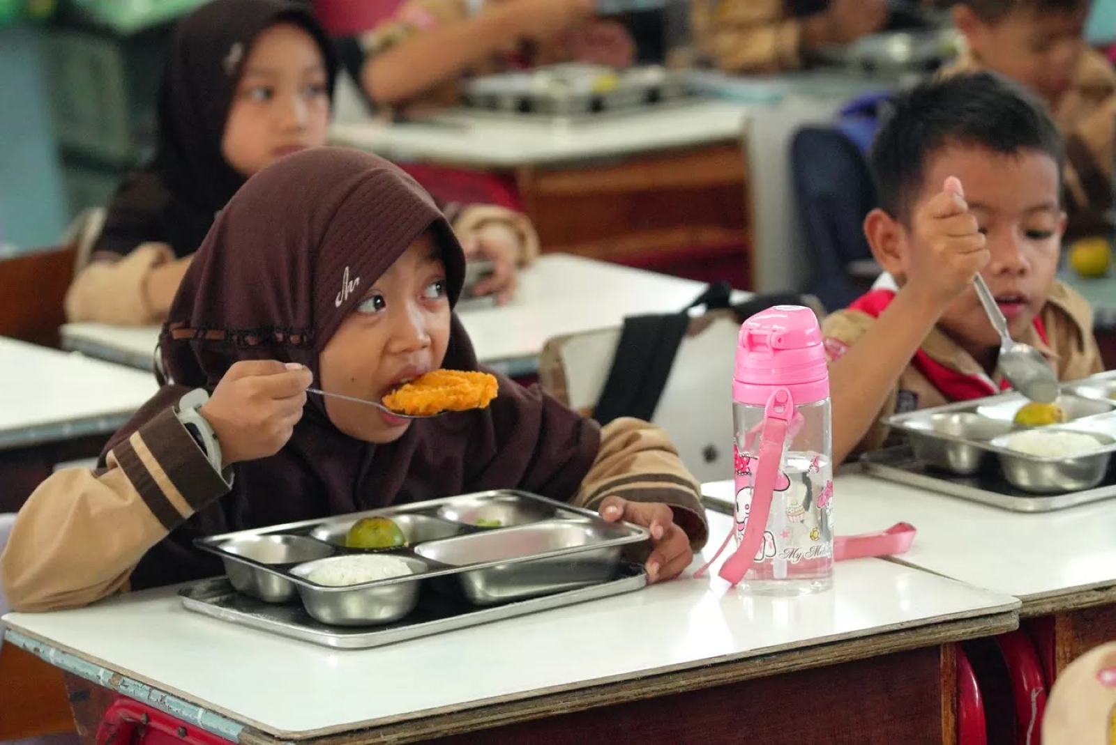 Siswa menyantap makanan pada program Makan Bergizi Gratis (MBG) di SDN 03 Jati Pulogadung, Jakarta.