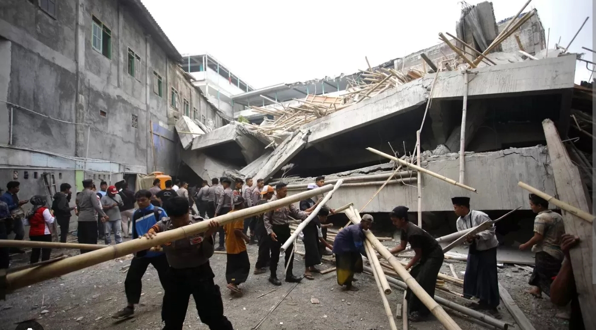 Petugas kepolisian bersama santri dan relawan menyingkirkan material bambu di lokasi reruntuhan Pondok Pesantren Al Khoziny, Buduran, Sidoarjo, Kamis (2/10/2025). (Foto Jawa Pos)