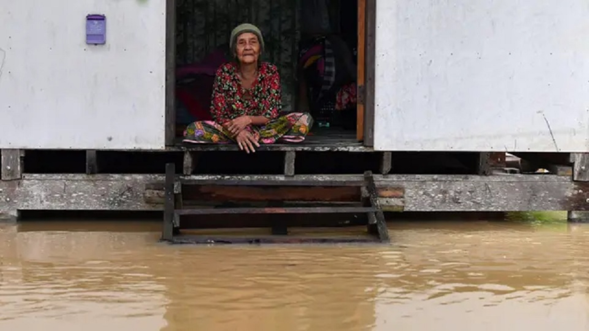 BANJIR: Seorang warga melihat banjir dari rumahnya di distrik Ran-ngea di provinsi Narathiwat, Thailand selatan.