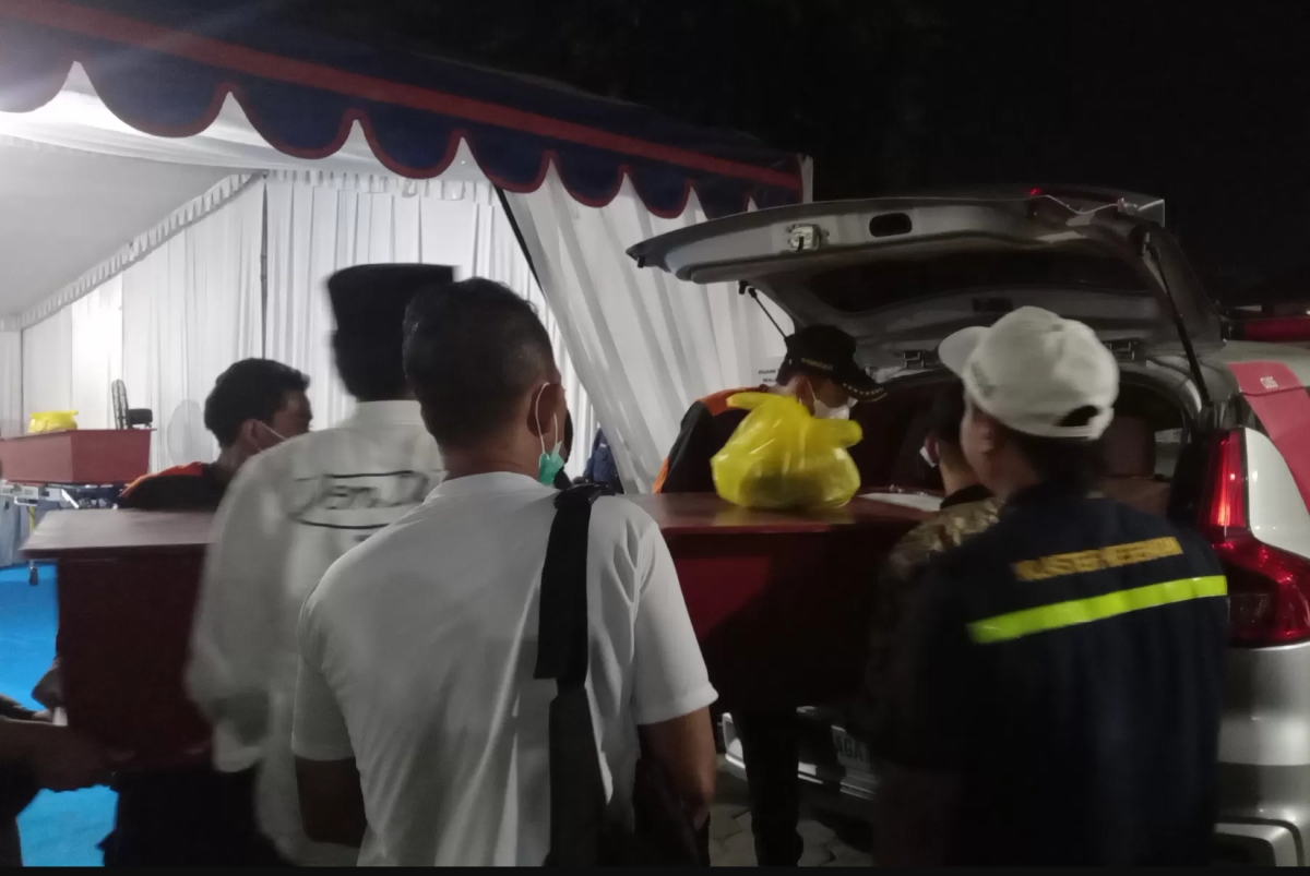 Petugas mengevakuasi peti jenazah korban ambruknya bangunan Pondok Pesantren Al Khoziny ke mobil ambulans di RS Bhayangkara Surabaya, Rabu malam (8/10). (Foto Jawa Pos)