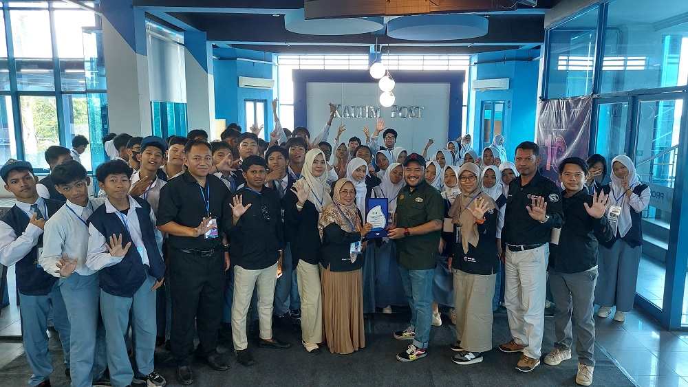 LIHAT DUNIA KERJA: Kepala Program DKV SMK 5 Samarinda Julia MY SKom menyerahkan cendera mata kepada Paksi Sandang Prabowo saat menggelar kegiatan Outing Class ke Kantor Gedung Biru Kaltim Post, Senin.