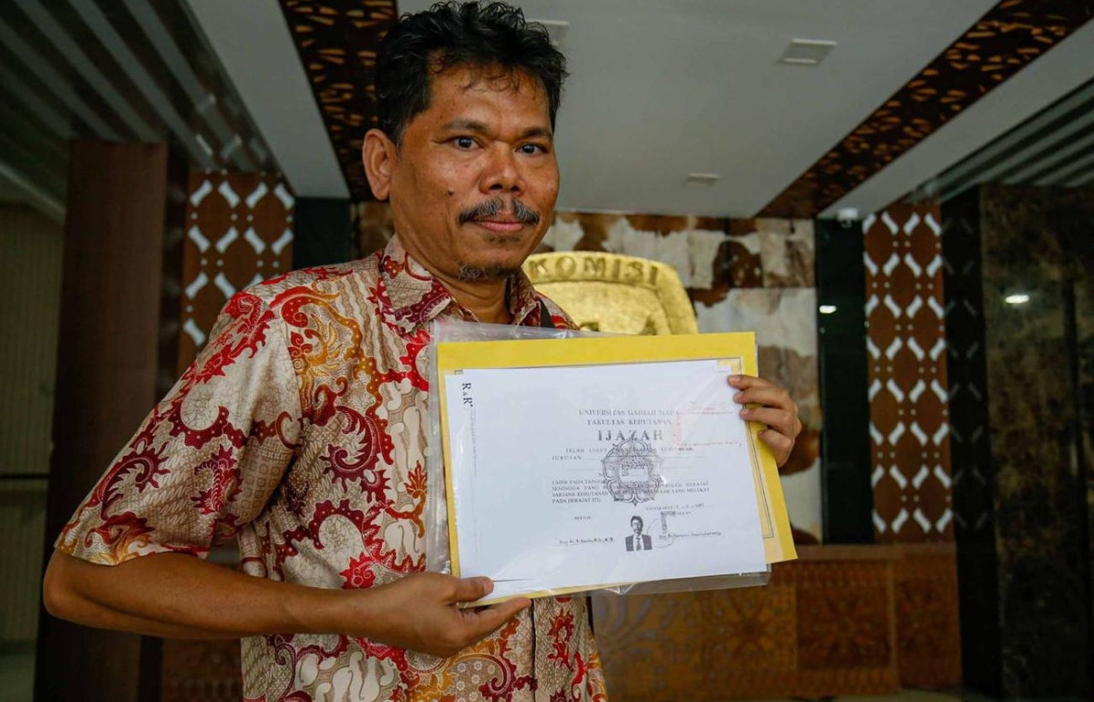 Pengamat kebijakan publik Bonatua Silalahi memperlihatkan salinan ijazah yang telah dilegalisasi di kantor KPU DKI Jakarta, Senin (13/10/2025).