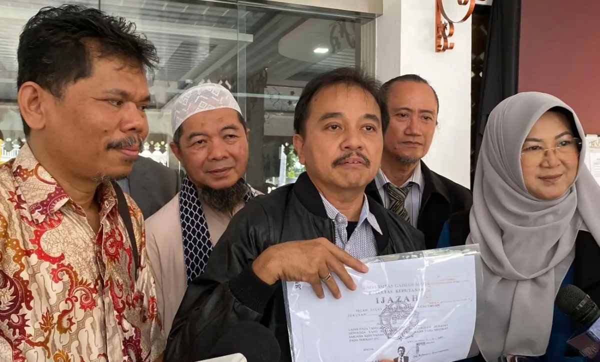 Pakar telematika Roy Suryo bersama sejumlah rekannya menunjukkan salinan ijazah yang disebut sebagai milik Joko Widodo usai menerima dokumen dari KPU DKI Jakarta, Senin (13/10/2025). (Foto Okezone)