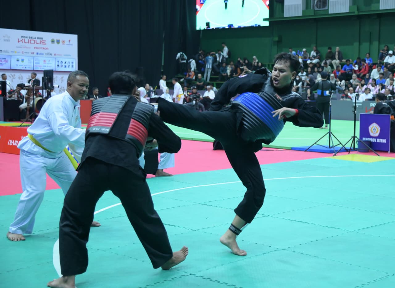 PENGALAMAN BERHARGA: Pesilat Kaltim Kandung Miftah (Biru) melepaskan tendangan ke pesilat Banten Rijal Mahendra. (DONI ADITYA)
