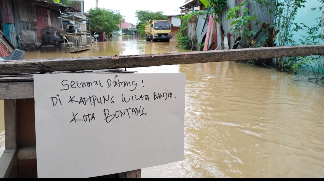 SINDIRAN: Warga Kelurahan Api-Api justru memasang tulisan di pembatas jalan karena akses tersebut tidak bisa dilintasi kendaraan akibat banjir. (ADIEL KUNDHARA/KP)