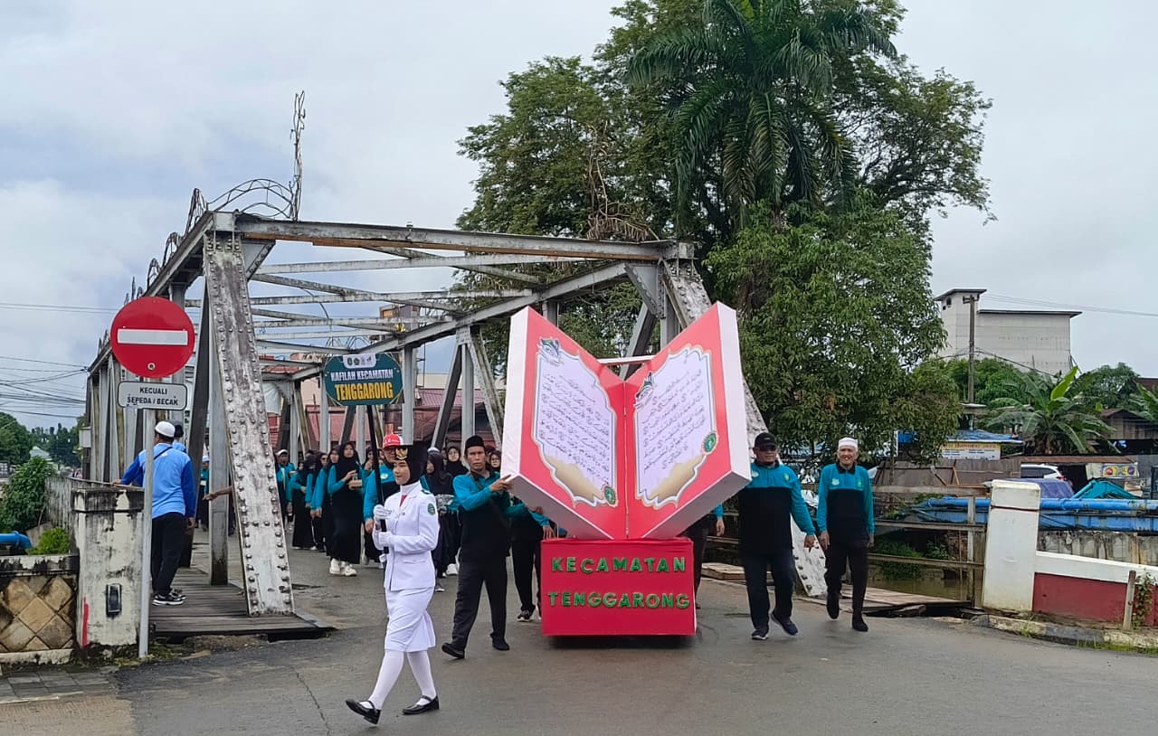Kafilah Kecamatan Tenggarong menampilkan replika Al-Qur&rsquo;an raksasa saat mengikuti Pawai Ta&rsquo;aruf MTQ ke-46 Tingkat Kabupaten Kukar di Jalan Monumen Timur, Tenggarong, Jumat (24/10/2025).  &nbsp;