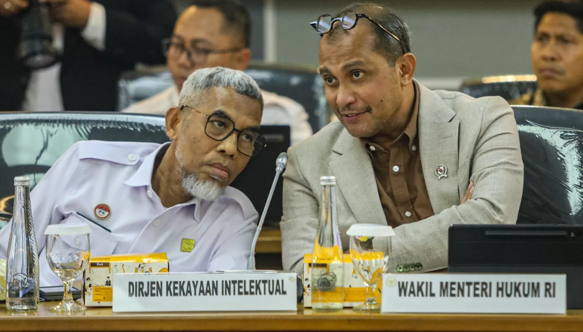 Wamen Hukum Edward Omar Sharif Hiariej (kanan) berbincang dengan Dirjen Kekayaan Intelektual Razilu (kiri) mengikuti RDPU dengan Komisi XIII DPR, Kamis (21/8/2025). (Salman Toyibi/Jawa Pos)
