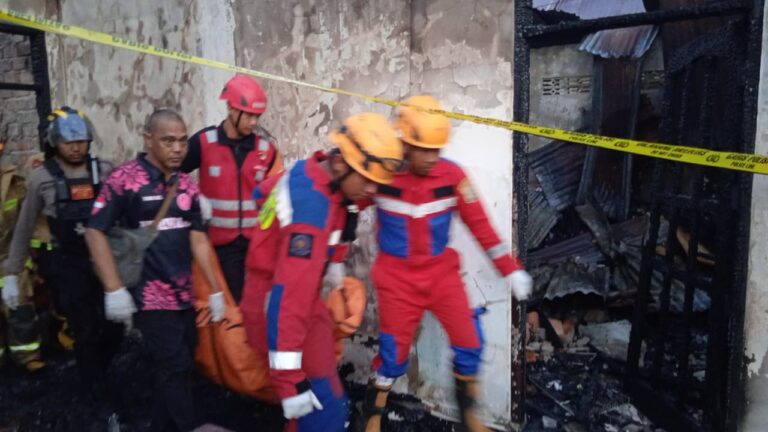KEBAKARAN: Setelah memadamkan api, tim gabungan mengevakuasi dua jasad dari dalam rumah.