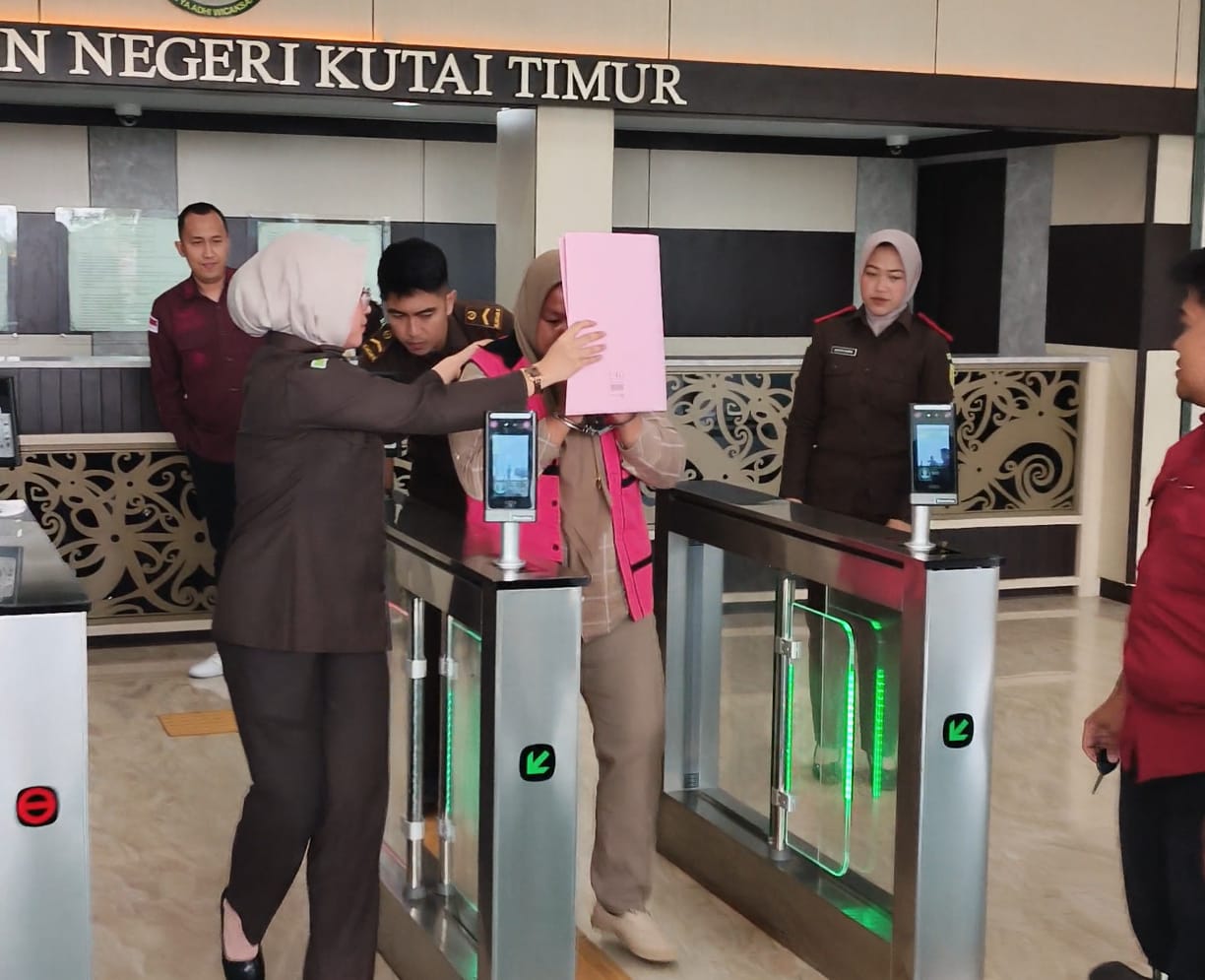 OKNUM: Tersangka J (rompi pink), Kaur Keuangan Desa Bumi Etam, usai menjalani pemeriksaan dan ditetapkan sebagai tersangka kasus dugaan korupsi pengelolaan APBDes senilai Rp 2,1 miliar.