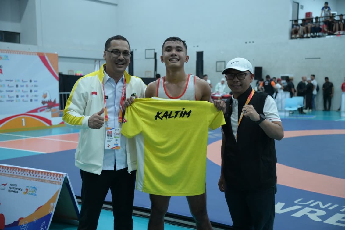 Muhammad Hasdam (tengah) melakukan selebrasi kemenangan bersama Plt Kadispora Muhammad Faisal (kiri).