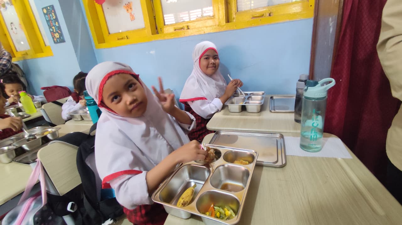 MAKAN BERSAMA: Beberapa siswa kelas 2 SD 002 di Kelurahan Bugis terlihat asyik menikmati menu MBG yang disajikan, pada hari pertama pelaksanaan MBG, Kamis (6/11).