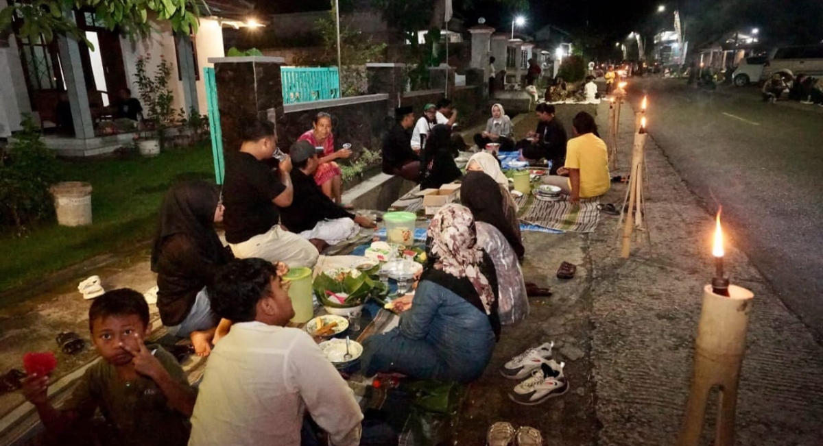 Suasana hangat Festival Ngopi Sepuluh Ewu di Desa Adat Kemiren, Banyuwangi. Warga dan wisatawan duduk lesehan di sepanjang jalan, menikmati kopi dan kudapan tradisional. (Foto JTV)