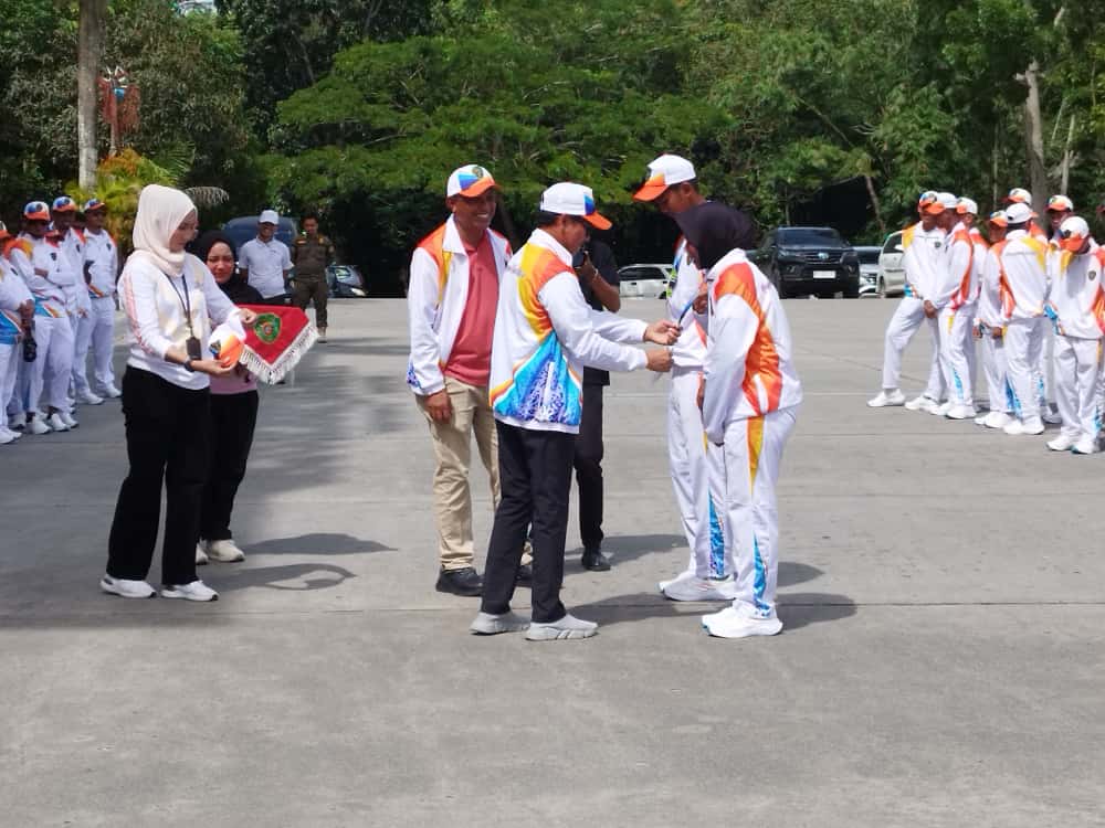 OPTIMISTIS: Andi Singkerru mendampingi Abdul Waris Muin menyematkan tanda peserta dalam prosesi pelepasan Popda Kaltim XVII tahun 2025 kontingen PPU, kemarin