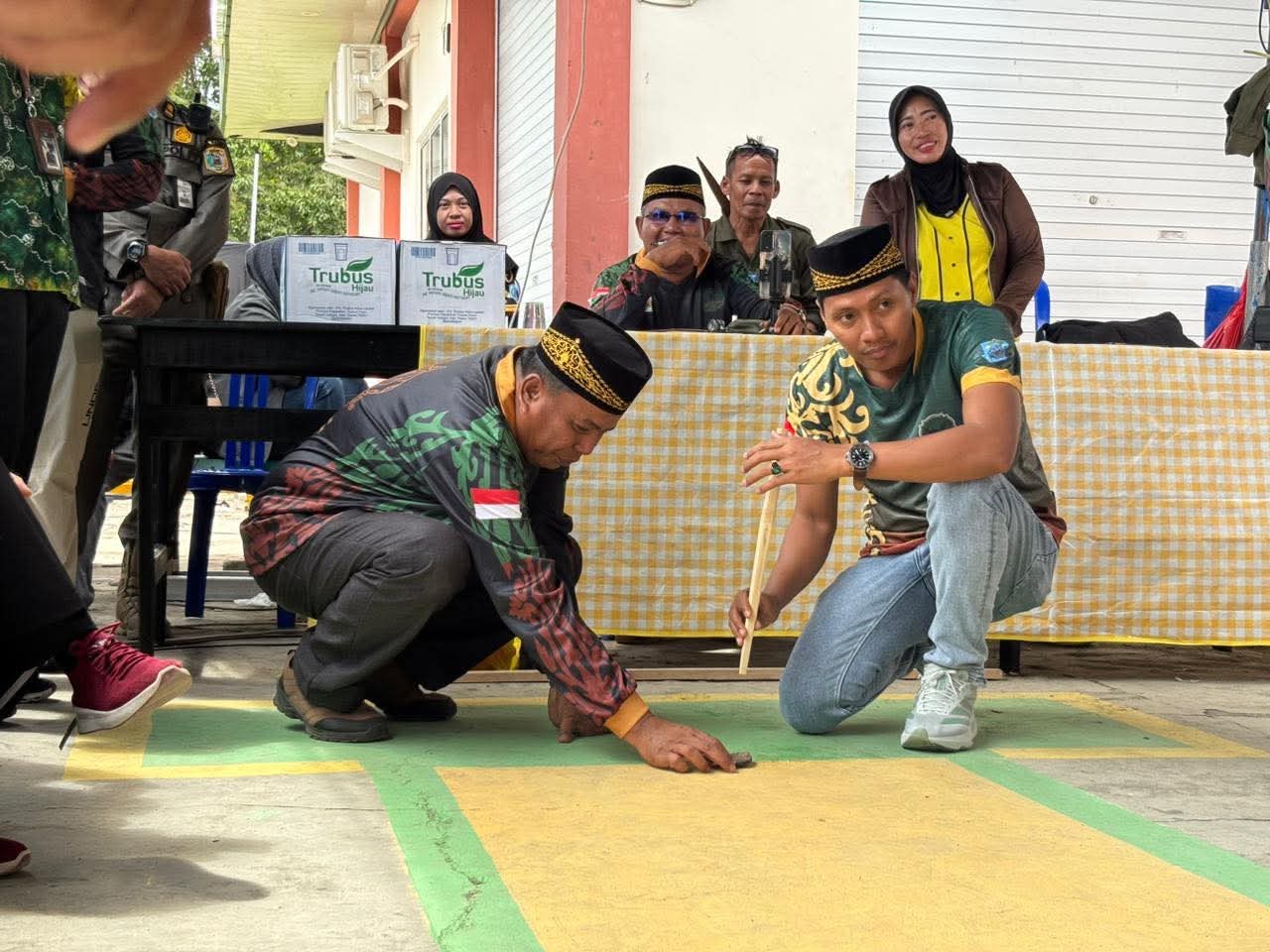 Anggota DPRD Paser Sukran Amin saat mencoba permainan tradisional pada momen Melas Taon 2025