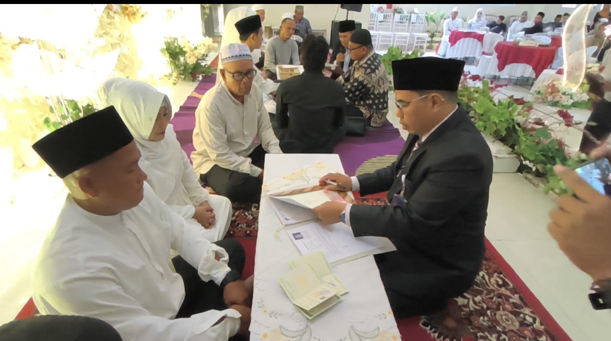Para pengantin usai menerima cinderamata dari panitia pelaksana dan buku nikah.
