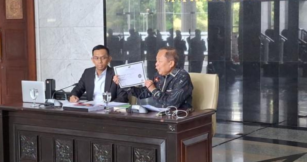 Hakim MK Asrul Sani memperlihatkan ijazah  doktoralnya saat jumpa pers di MK pada senin 17 November 2025.