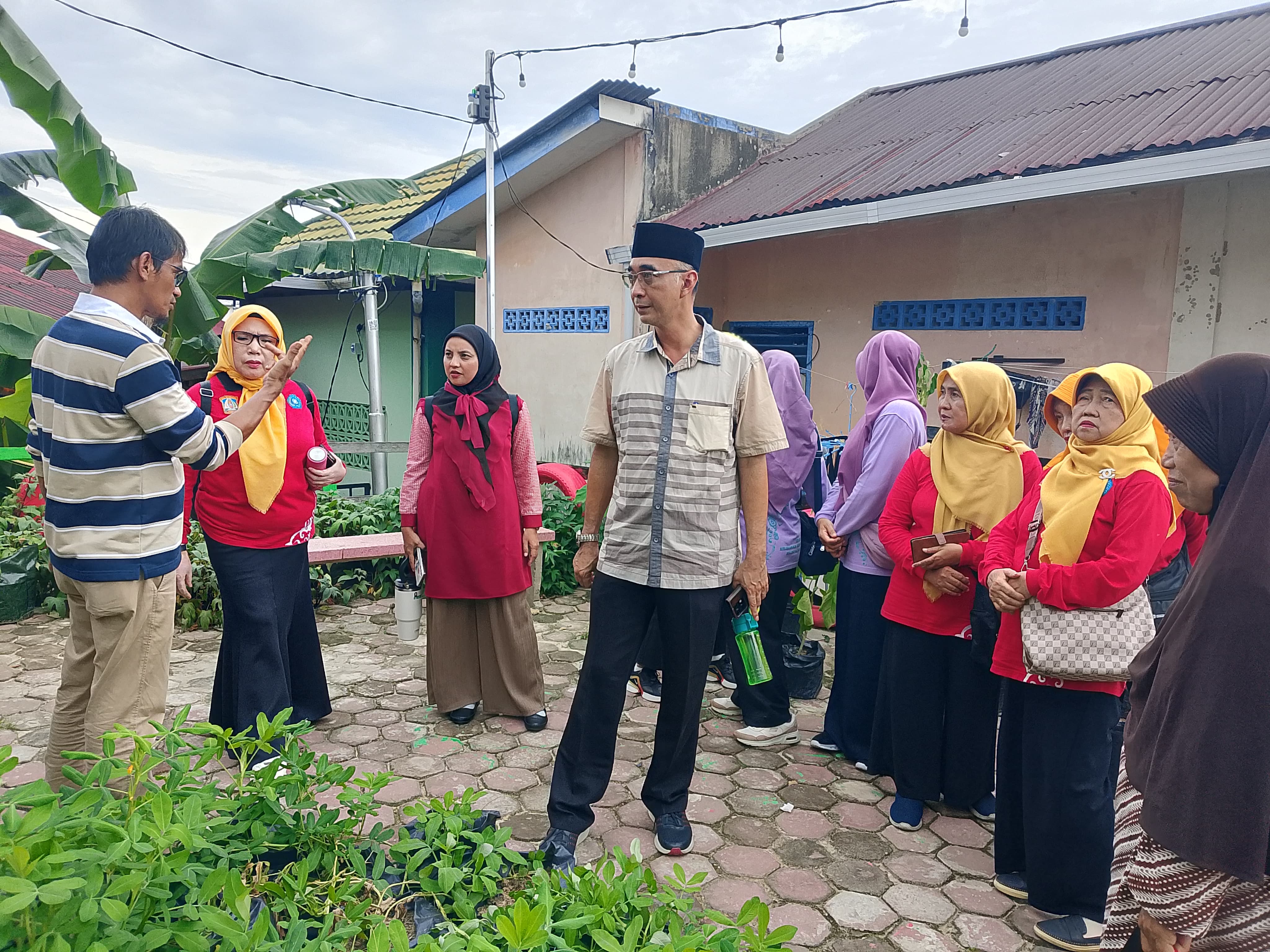 Suwanto (kiri) menjelaskan apa saja di Kampung Bungas kepada camat Balikpapan Tengah saat menyambangi kawasan juara CGH Kota Balikpapan 2025 ini.