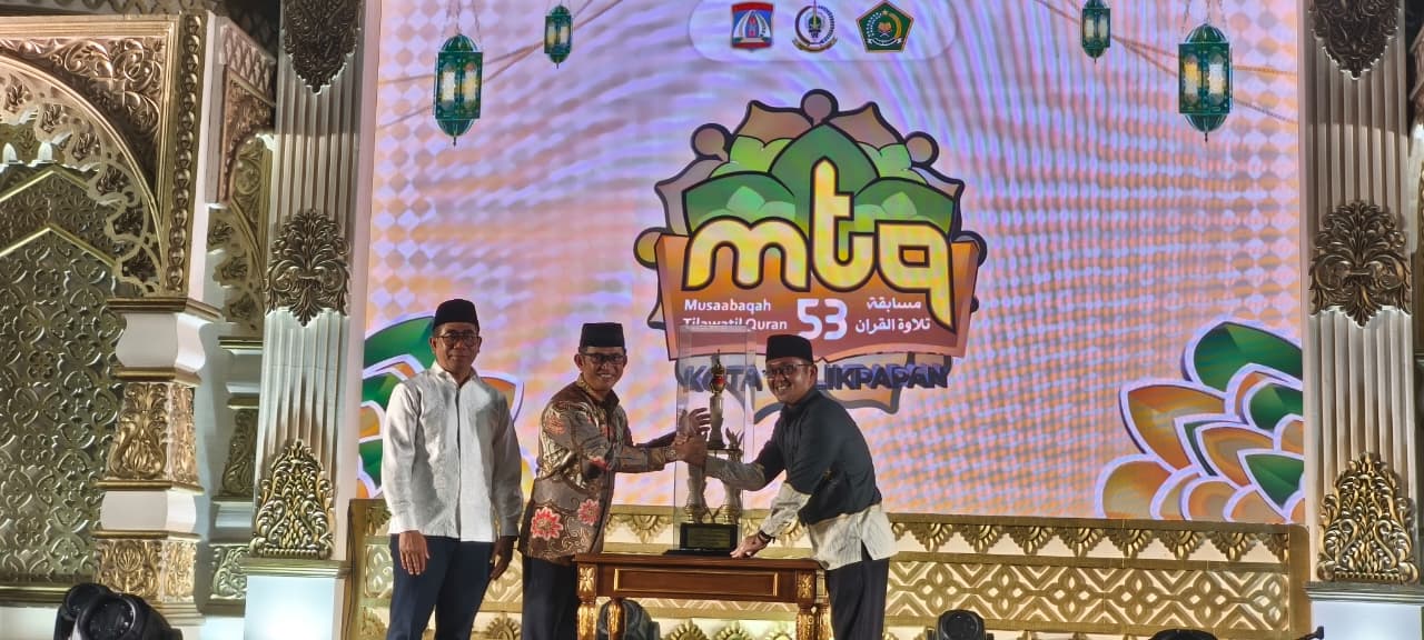 SERAHKAN PIALA: Rahmad Mas&rsquo;ud menyerahkan piala bergilir kepada kafilah peraih juara umum yang diraih Balikpapan Utara, diterima oleh Camat Balikpapan Utara, Umar Adi.