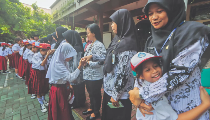 Ilustrasi siswa SD di Solo memeluk guru saat peringatan Hari Guru Nasional.