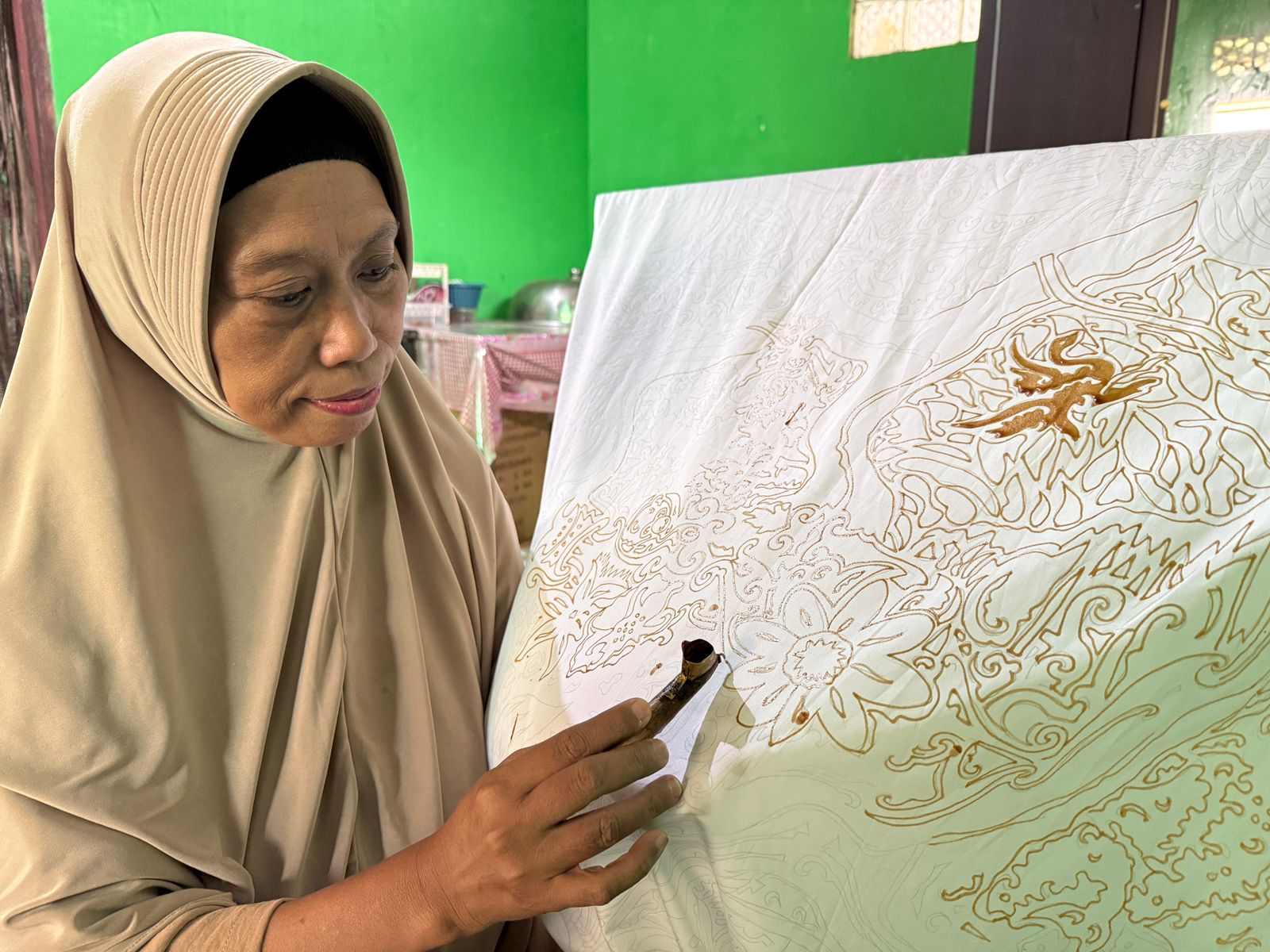 TEKUN: Akrab dengan canting dan lilin malam, membuat Lilis piawai menggores di atas kain. Normalnya, dia produksi 5-7 potong kain sebulan.