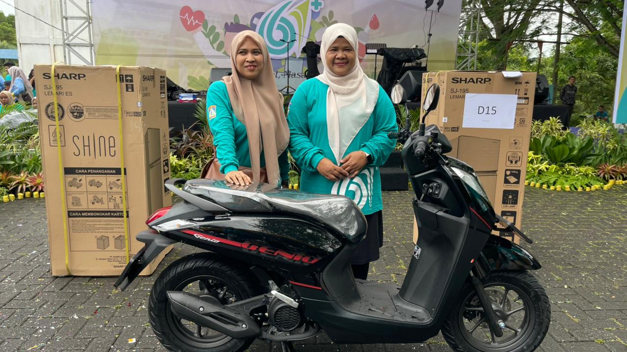 BERUNTUNG: Alwiati menyerahkan hadiah grand prize satu unit sepeda motor kepada insan kesehatan yang beruntung, Minggu (23/11)