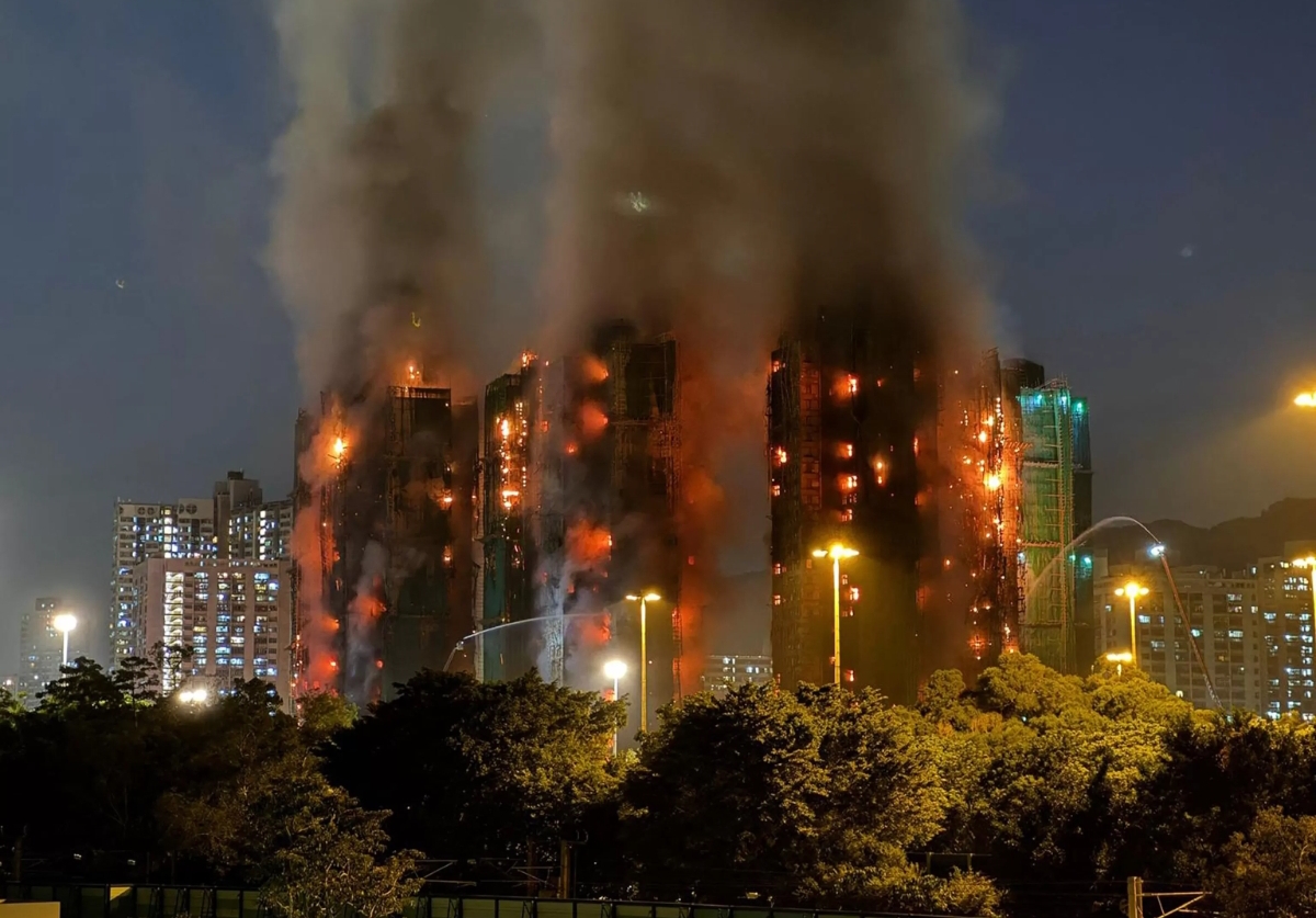 Api membakar kompleks apartemen bertingkat di Hong Kong pada malam hari. Sejauh ini 44 orang dilaporkan tewas termasuk dua warga Indonesia. (FOTO: IST)