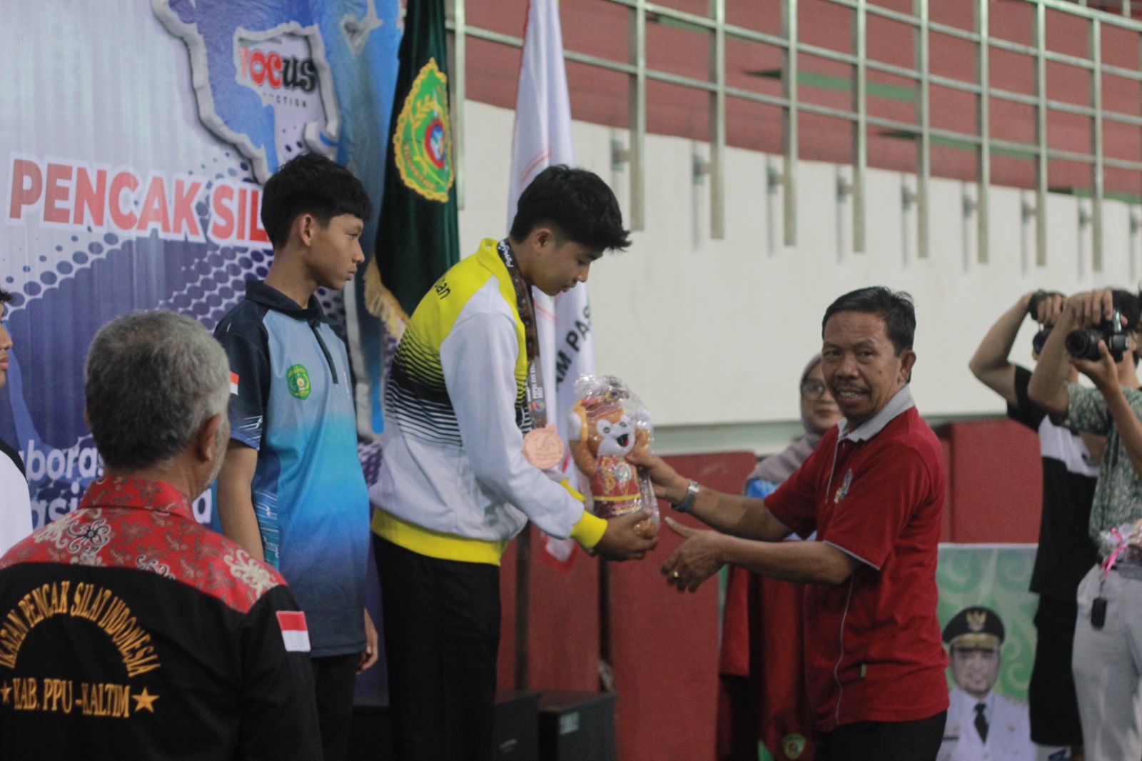 APRESIASI: Anggota DPRD PPU, Roman Rading, mengalungkan medali kepada para juara cabor pencak silat.