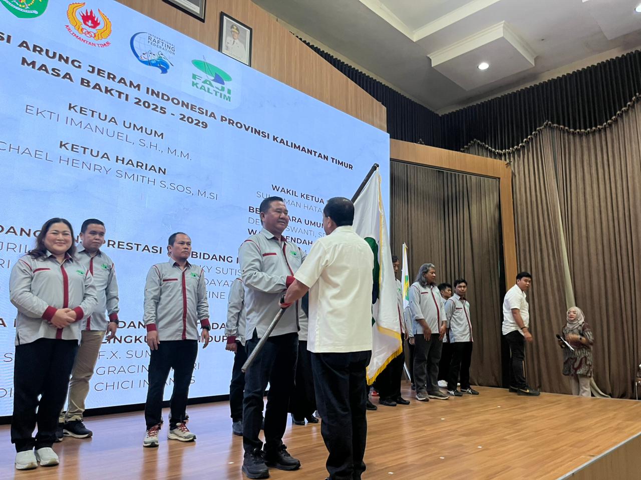 Ekti Imanuel menerima bendera dari Ketua Umum PB FAJI Mayjen TNI Mar (Purn) Saud Tambatua.