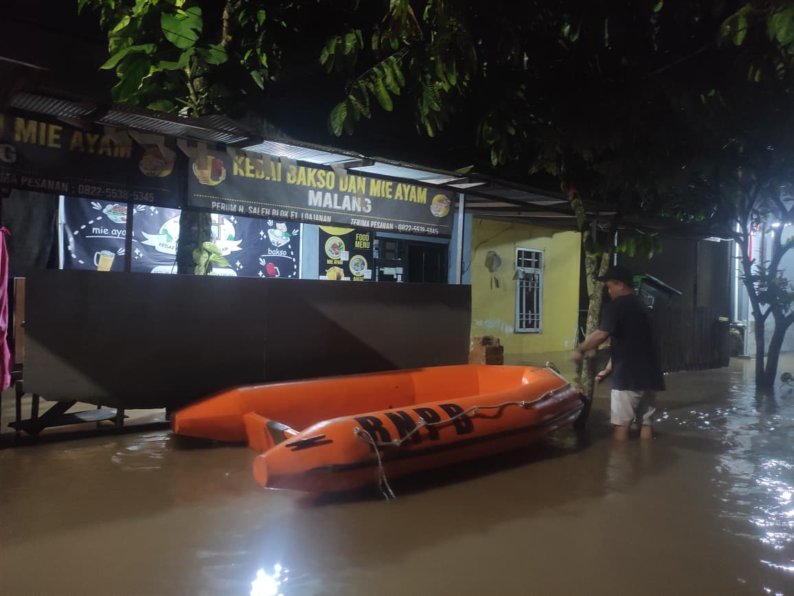 BANTU: Tim BPBD Samarinda membawa perahu karet untuk membantu warga yang memerlukan evakuasi, di perum Haji Saleh, Kecamatan Loa Janan Ilir, Sabtu (29/11).