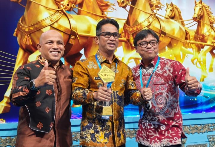 PENGHARGAAN: Wali Kota Balikpapan Rahmad Mas&rsquo;ud (tengah) memegang piala TP2DD Kota Terbaik 2025 untuk Kawasan Kalimantan didampingi Kepala BPPDRD Balikpapan Idham (kiri).