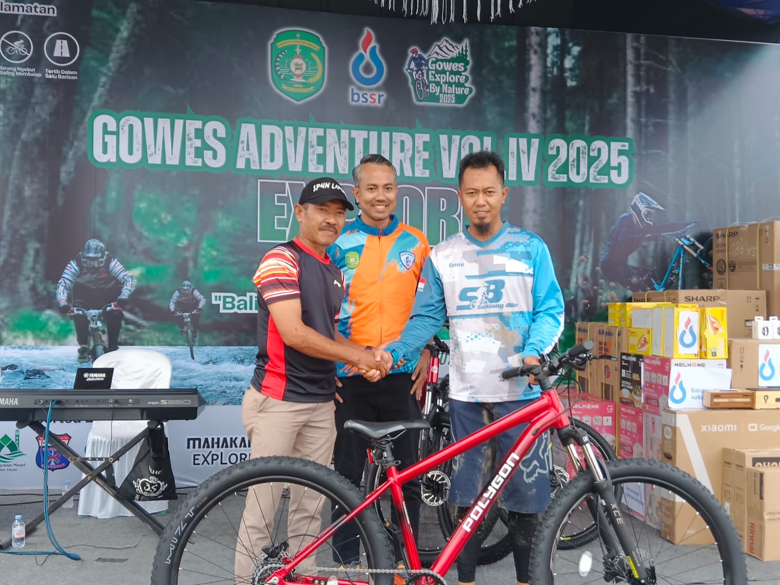 &nbsp;  Kades Bakungan Arlusdiansyah (kiri) disaksikan Anandya Wardhana (tengah) serahkan hasil undian doorprize sepeda kepada peserta gowes yang beruntung.