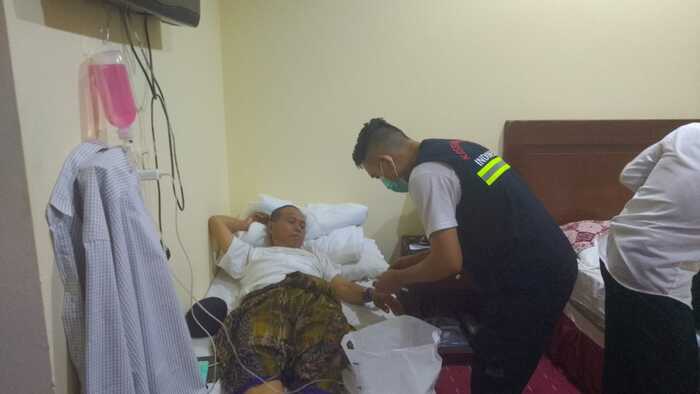 Ilustrasi petugas kesehatan haji melakukan penanganan medis terhadap jamaah yang jatuh sakit.