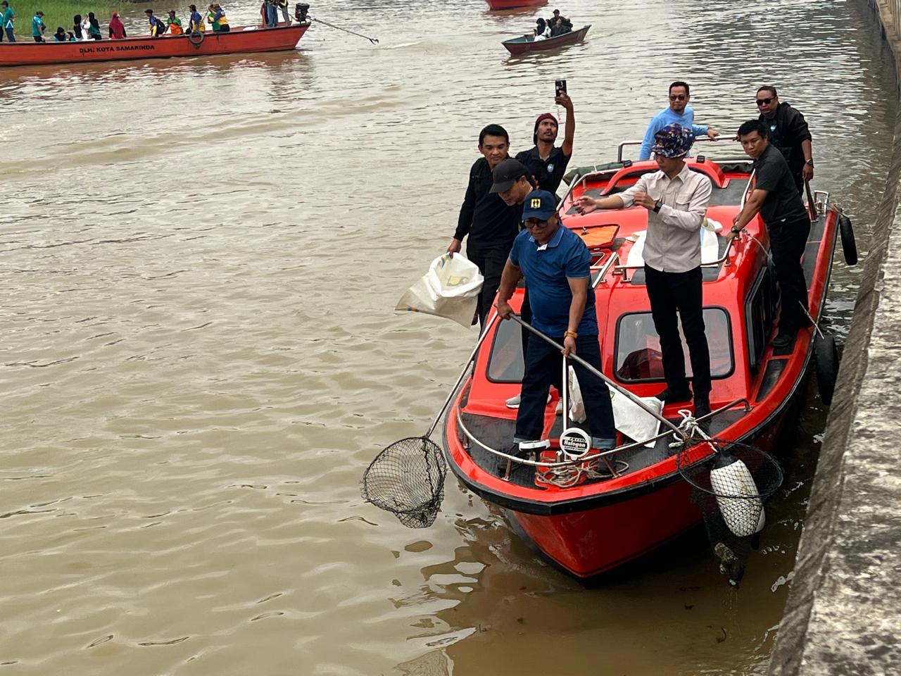 Saefuddin Zuhri (depan) memegang jaring pengangkut sampah dalam kegiatan pembersihan sampah sungai Karang Mumus, Sabtu (7/11).  &nbsp;
