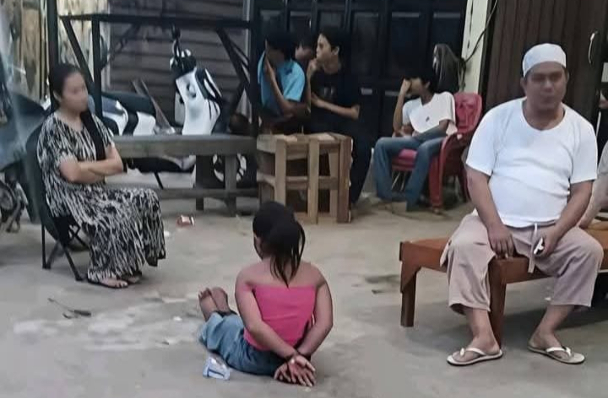 Seorang anak perempuan terlihat duduk di depan sebuah toko di Kota Padang, Sumatra Barat, dengan posisi tangan berada di belakang tubuhnya. (FOTO: IST)