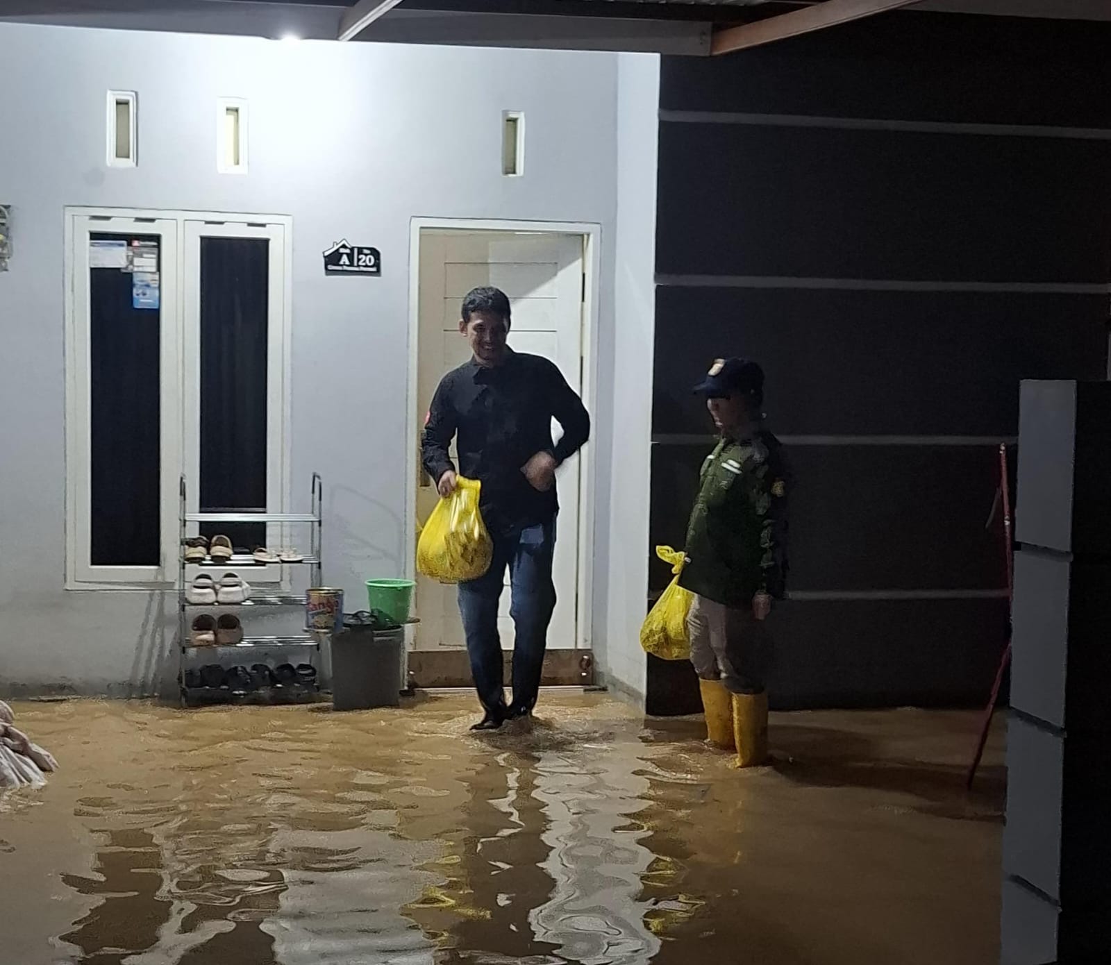 TINJAU LOKASI: Lurah Api-Api Hadha Sulistiyono menyerahkan bantuan berupa paket makanan kepada warga yang terdampak banjir.