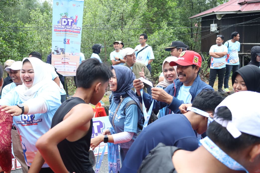 Abdul Waris Muin mengalungkan medali bagi para peserta Danum Taka Run.  &nbsp;