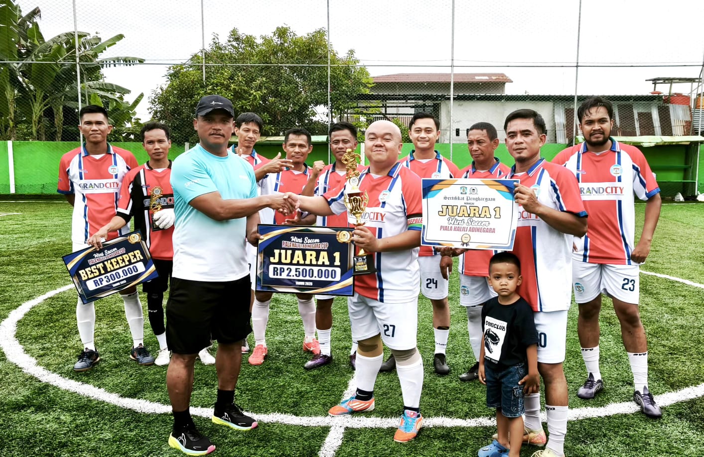 Halili Adinegara (kiri) menyerahkan hadiah kepada kapten tim Baltara Agung PS yang menjadi juara turnamen mini soccer Piala Halili Adinegara.