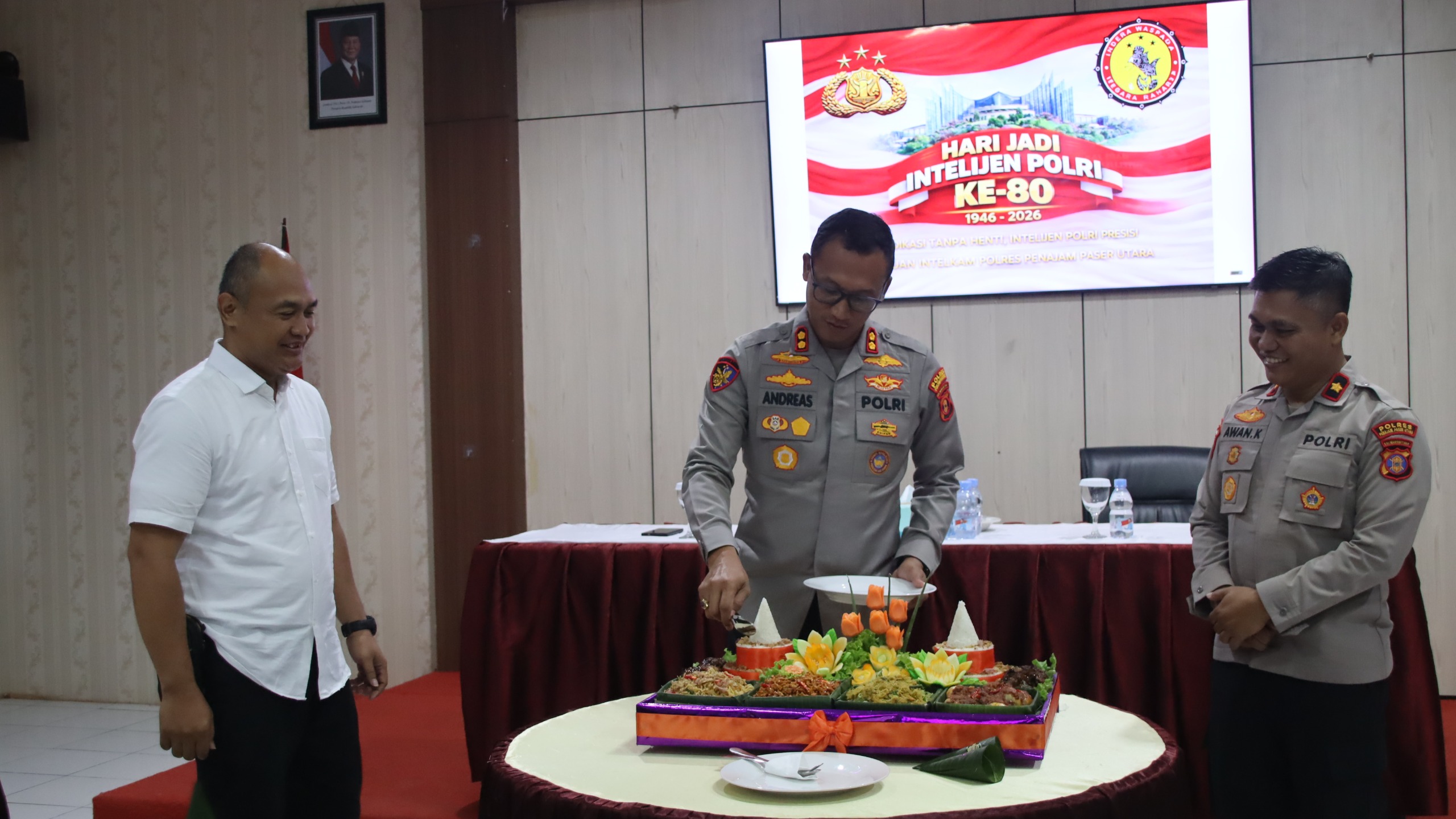TUMPENG: Kapolres PPU, AKBP Andreas Alek Danantara, memotong tumpeng HUT ke-80 Intelijen Polri 2026.
