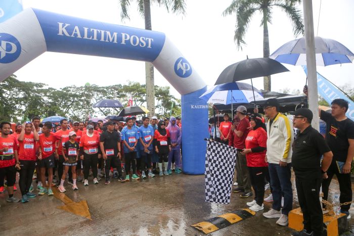 Ratusan peserta mengikuti Kaltim Post Fun Run 2026 yang digelar di kawasan Taman Bebaya, Samarinda, Minggu (11/1). Meski diguyur gerimis, pelari tetap antusias menempuh rute 5 kilometer. (RAMA/KP)