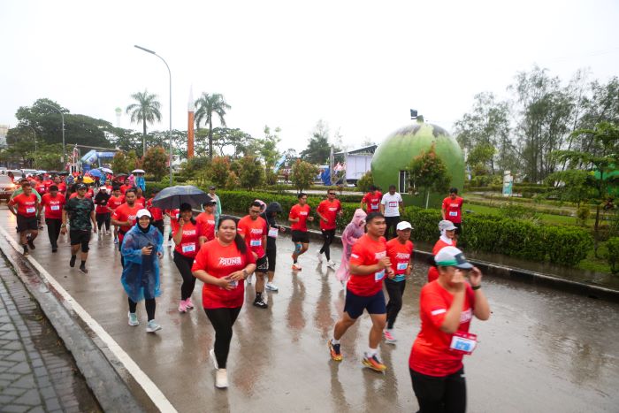 Para peserta mengikuti Kaltim Post Fun Run 2026 yang digelar di kawasan Taman Bebaya, Samarinda, Minggu (11/1). Meski diguyur gerimis, pelari tetap antusias menempuh rute 5 kilometer. (RAMA/KP)