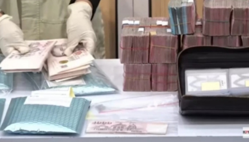 Petugas KPK menunjukkan barang bukti uang tunai dan dokumen yang disita dalam OTT di KPP Madya Jakarta Utara. (YouTube KPK)