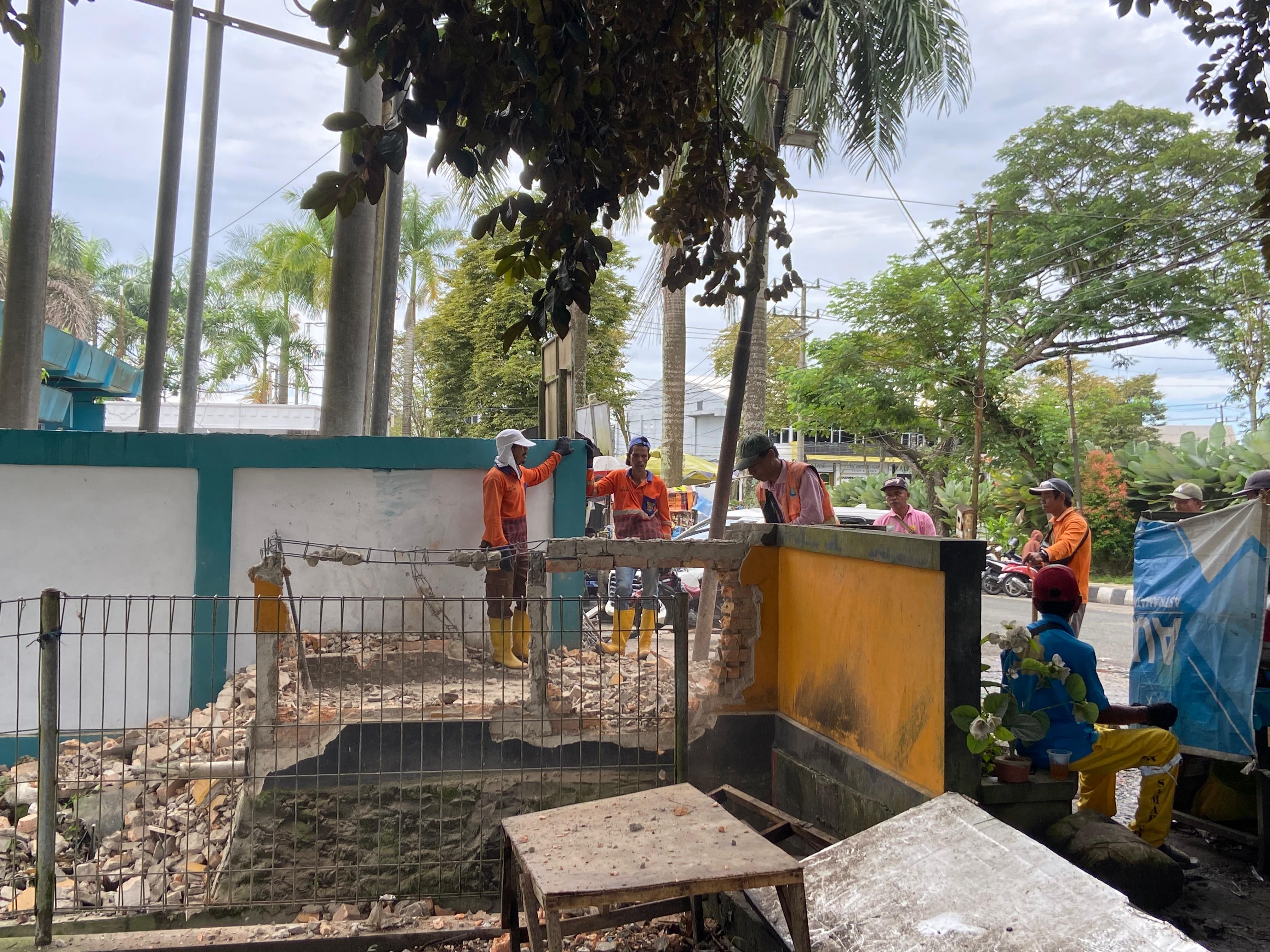PINDAH: Beberapa petugas DLH membongkar dinding eks TPS di tepi Jalan Ruhui Rahayu Kelurahan Gunung Kelua Kecamatan Samarinda Ulu, Kamis (15/1).  (IST)