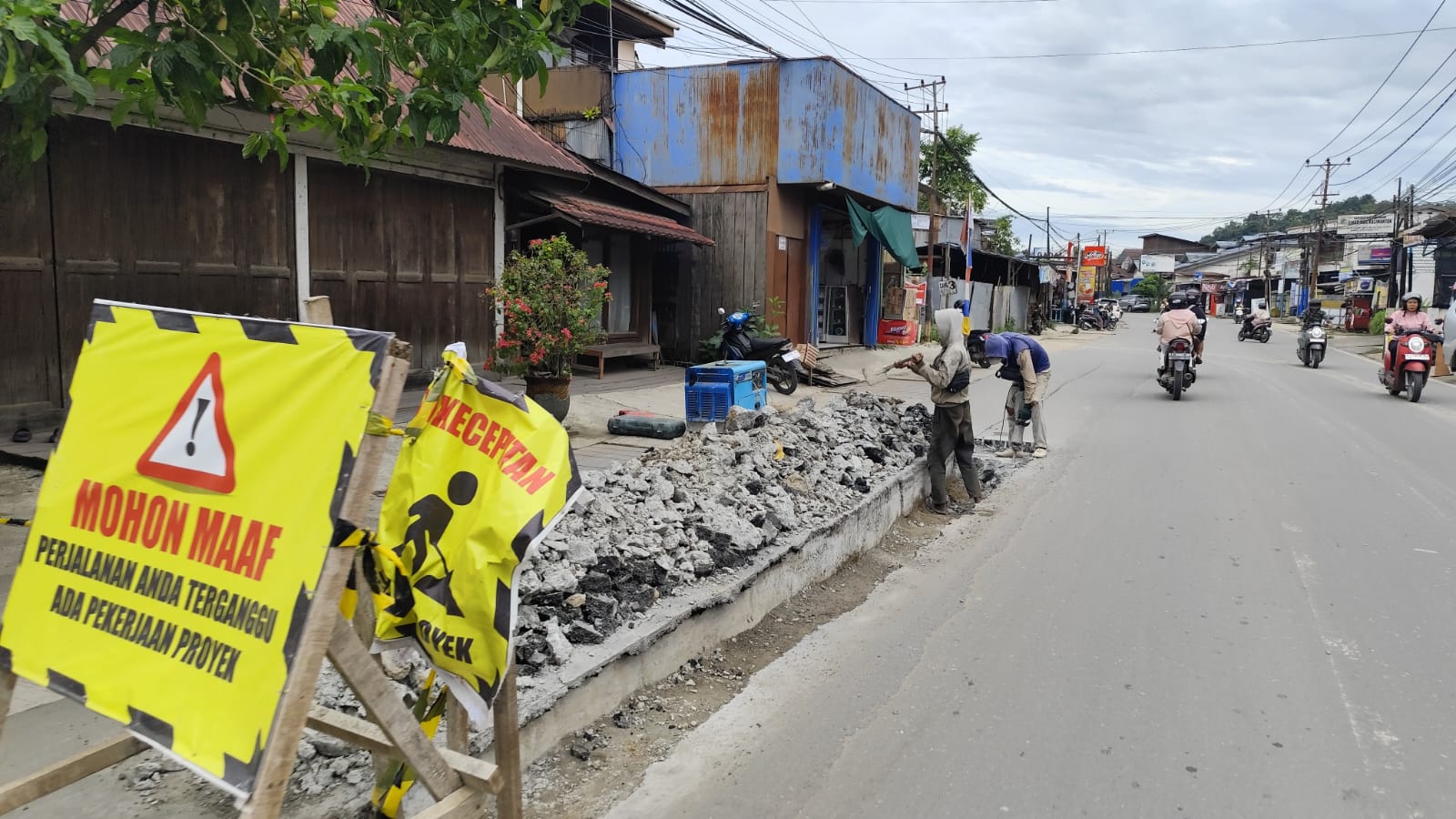 KUPAS: Beberapa pekerja terlihat mengupas lapisan aspal-beton di Jalan P Suryanata Kecamatan Samarinda Ulu setelah mengalami penurunan. (DENNY SAPUTRA/KP)