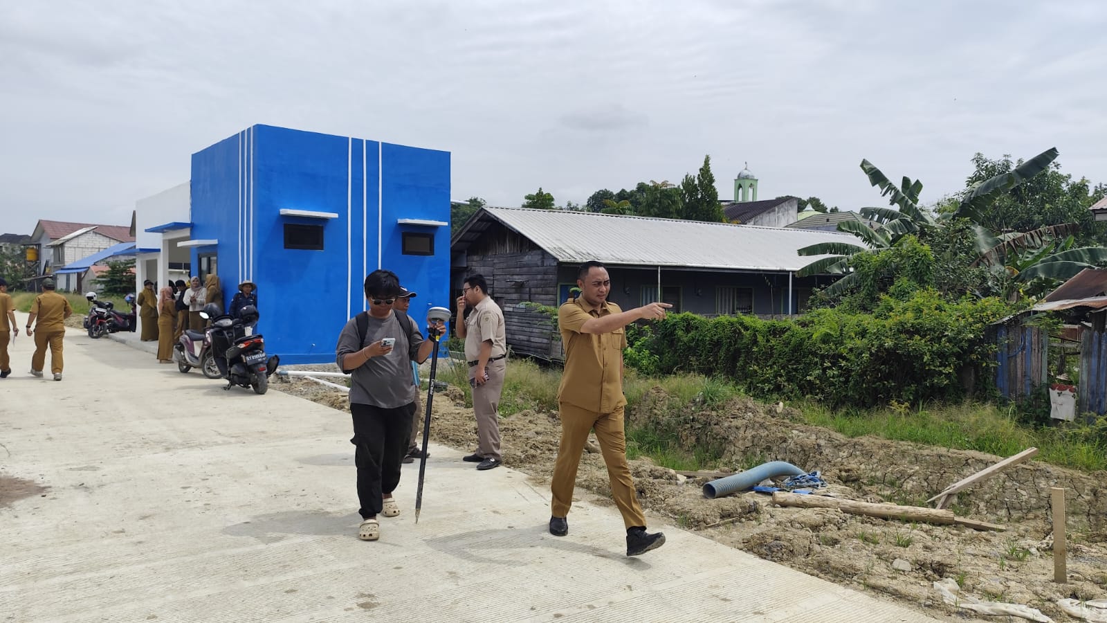 PASTIKAN: Deni Wardana (kanan) ketika mendampingi tim pengukur dari BPN Samarinda di sekitar outlet kolam retensi Sempaja, Selasa (20/1). (DENNY SAPUTRA/KP)